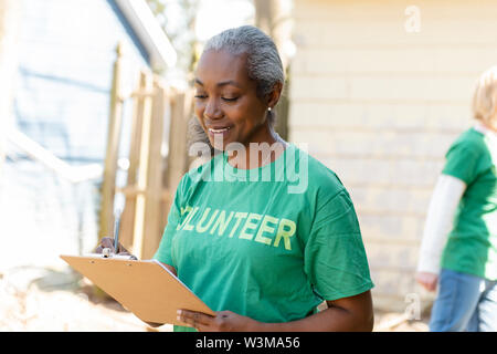 Donna matura volontario con appunti Foto Stock