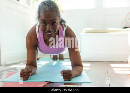 Sorridente donna matura fare yoga Foto Stock