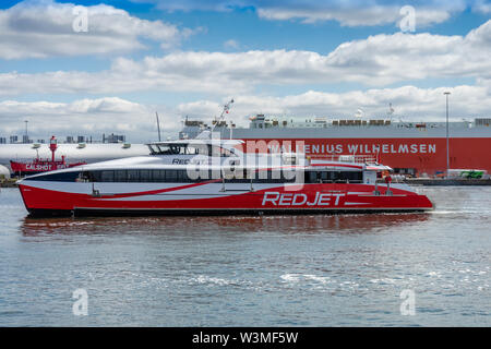 Ad alta velocità a piedi passeggero catamarano Jet rosso 6 di proprietà dell'Imbuto Rosso compagnia di traghetti che arrivano al molo della città nel porto di Southampton, England, Regno Unito Foto Stock