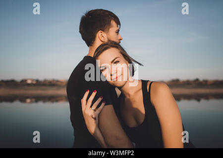 Coppia giovane che abbraccia dal lago Foto Stock