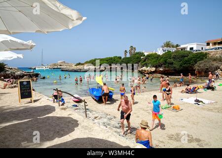 La spiaggia e la baia di Sa Caleta in una calda giornata estiva,Cala Santandria Ciutadella Minorca isole Baleari Spagna Europa Foto Stock