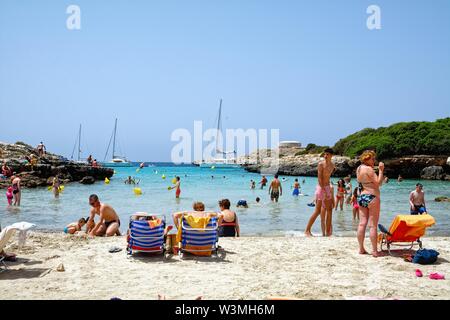 La spiaggia e la baia di Sa Caleta in una calda giornata estiva,Cala Santandria Ciutadella Minorca isole Baleari Spagna Europa Foto Stock