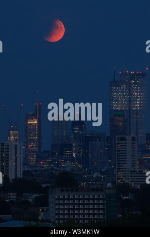 La luna piena "Buck Moon" che sorge su Londra. Un'eclissi lunare parziale vista da Parliament Hill a Hampstead Heath, Londra, Inghilterra, Regno Unito, Regno Unito Foto Stock