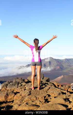 Il successo e il raggiungimento - escursionismo donna sulla sommità del mondo. Felice il tifo donna nel gesto vincente eccitati avendo raggiunto il vertice della montagna est Maui Vulcano Haleakala national park Hawaii. Foto Stock