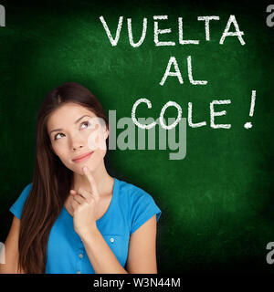 Vuelta al cole - Collegio Spagnolo studente universitario donna pensiero torna a scuola scritto in spagnolo sulla lavagna dalla femmina sulla lavagna verde. Lingua spagnola presso il college o high school. Foto Stock