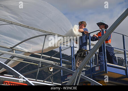 Greymouth, Nuova Zelanda, dicembre 12, 2018: Commercianti fissare la plastica su un nuovo tunnel house. Foto Stock