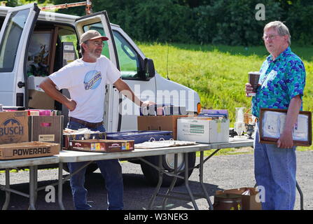 Durham, CT / STATI UNITI D'America - 24 Giugno 2019: il venditore ed il compratore in un mercato delle pulci strike una conversazione amichevole Foto Stock