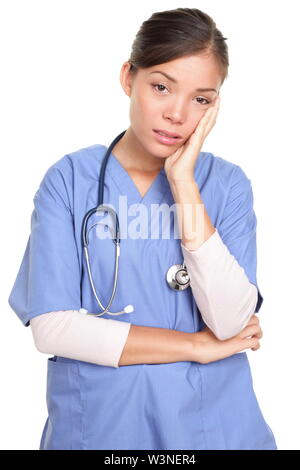 Ritratto di donna infelice chirurgo con la mano sulla faccia in piedi isolato su sfondo bianco Foto Stock