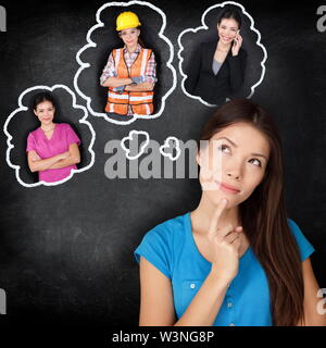 Istruzione e carriera scelta opzioni - studente pensare del futuro. Giovane donna asiatica contemplando le opzioni di carriera sorridente guardando il pensiero di bolle su una lavagna con diverse professioni Foto Stock