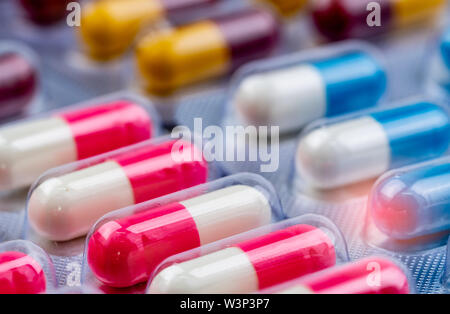 Messa a fuoco selettiva su rosa-bianco capsula di antibiotico pillole in confezione blister. Industria farmaceutica. Farmaco antibiotico resistenza concetto. Cappuccio con rivestimento antimicrobico Foto Stock