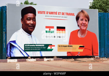Archiviato - 27 maggio 2019, Libia, Niamey: un cartellone vicino al palazzo presidenziale mostra ritratti di Mahamadou Issoufou, presidente del Niger, e Angela Merkel, il cancelliere. Il cancelliere ha visitato la stato dell'Africa occidentale all'inizio di maggio 2019. L UNHCR aveva evacuato numerosi rifugiati provenienti da politicamente instabili in Libia per portare la loro sicurezza in Niger. Essi sono stati liberati da condizioni peggiori in Libia e portato in Niger con la promessa di essere reinsediati in Europa. Ma molti migranti non ci sarebbe di rimanere nel limbo per mesi o addirittura anni prima che potesse mai messo piede sul suolo europeo. ( Foto Stock