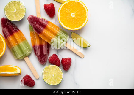 Frutta estiva ghiaccioli fatti con calce arancione e lamponi Foto Stock