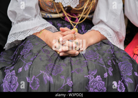 Una Donna vestita in tipico costume sardo con diverse ornamentali sardi gioielli d'oro. Tipico sardo. Foto Stock