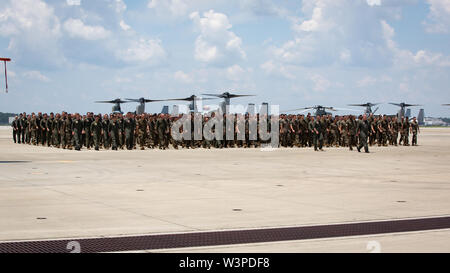 Stati Uniti Marines e velisti assegnati per mezzo marino Tiltrotor Squadron (VMM) 264 a piedi in formazione durante un homecoming ricevimento al Marine Corps Air Station New River, North Carolina, luglio 14, 2019. I marines e marinai restituito da una distribuzione con il ventiduesimo Marine Expeditionary Unit. (U.S. Marine Corps foto di Cpl. Cody Rowe) Foto Stock