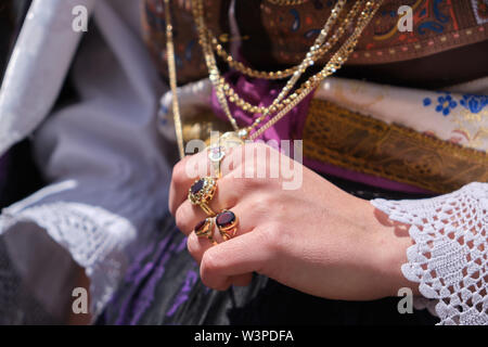 Una Donna vestita in tipico costume sardo con diverse ornamentali sardi gioielli d'oro. Tipico sardo. Foto Stock