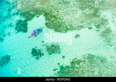 Barca su una barriera corallina. Superficie del mare con un atollo, barriere coralline. Mare shoal e profondità. Seascape con imbarcazione turistica. Foto Stock