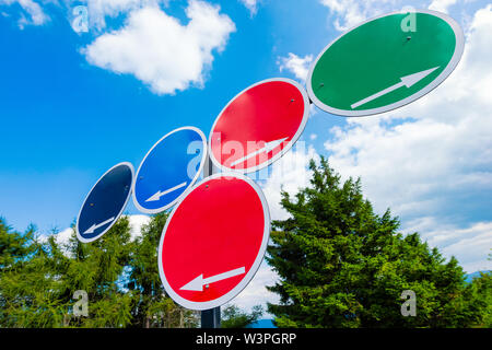 Segni di scelta - colorati segni circolari con frecce bianche con spazio per riempire il contenuto contro il cielo blu Foto Stock