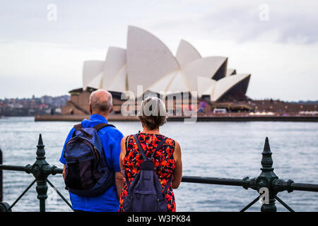 Il Sydney Opera House è un centro di arti dello spettacolo multi-luogo identificato come uno degli edifici più caratteristici del 20th.Couple watching oper Foto Stock