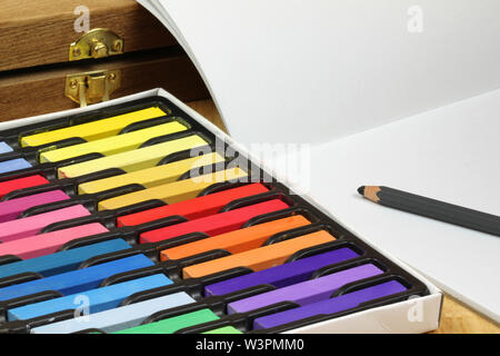 Multicolore di chalk pastelli, cartuccia di carta e scatola di legno. Artista's tools Foto Stock