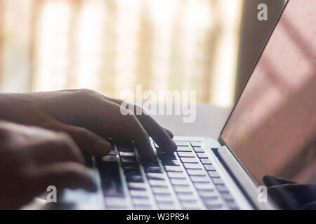 Uomo d'affari che utilizza un computer portatile. Primo piano delle mani maschili che digitano sulla tastiera del computer portatile. Concetto di lavoro aziendale. Blogger, giornalista che scrive nuovo articolo Foto Stock