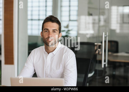 Fiducioso giovane imprenditore lavora presso il suo Ufficio escursioni Foto Stock