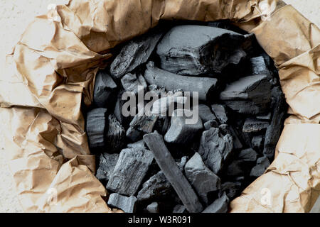 Nero carbone in un sacchetto di carta. Carbone di legna per accendere il  fuoco in una griglia Foto stock - Alamy