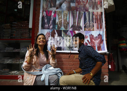 Kathmandu, Nepal. 17 Luglio, 2019. Una donna mostra il suo decorate a mano con henna sulla Shravan, un mese quando le donne culto Signore Shiva, lungo una strada a nuova strada a Kathmandu, Nepal Mercoledì, 17 luglio 2019. In questo mese le donne e le ragazze e mantenere veloce e adornano verde. Le ragazze nubili mantenere veloce su lunedì al desiderio di ottenere il marito di sua scelta mentre le donne sposate tenere il veloce per la buona salute dei loro mariti e i membri della famiglia. Credito: Skanda Gautam/ZUMA filo/Alamy Live News Foto Stock