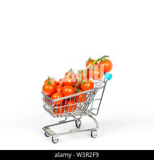 Miniatura carrello riempito con piccoli pomodori ciliegia isolato su bianco Foto Stock