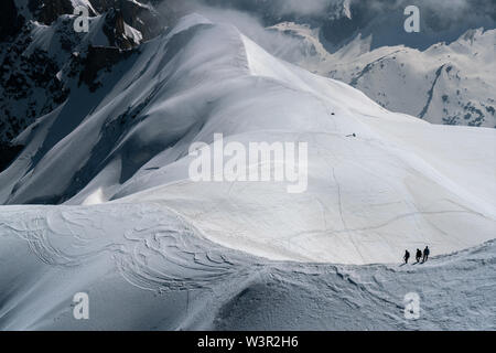 Gli alpinisti scendendo verso il basso per un ghiacciaio da Aiguille du Midi a Chamonix, Francia Foto Stock