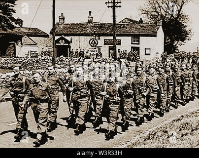 Una news foto scattata in WWII della locale Home Guard marching passato l'Anchor Inn al villaggio di Tideswell vicino a Buxton, nel distretto di picco del Derbyshire, Regno Unito. (Nota il telefono AA scatola) Foto Stock