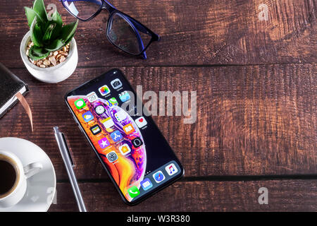 Galati, Romania - 29 Maggio 2019: i computer Apple iPhone XS su mobili di lusso in legno smartphone - telefono con display OLED. Scrivania da ufficio con smart p Foto Stock