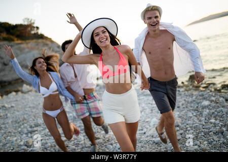 Gruppo di entusiasti giovani amici divertendosi insieme a lui beach Foto Stock