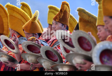 Xigaze, la Cina della regione autonoma del Tibet. 17 Luglio, 2019. I monaci frequentare un display Thangka rituale al monastero di Tashilhunpo in Xigaze, a sud-ovest della Cina di regione autonoma del Tibet, 17 luglio 2019. Thangka sono Buddista Tibetana opere dipinte su cotone o seta. I dipinti di soggetto religioso può essere fatta risalire al X secolo e tipicamente rappresentano Divinità buddiste. Credito: Chogo/Xinhua/Alamy Live News Foto Stock