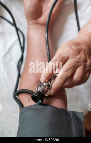 POV-medico pazienti controlla la pressione del sangue, fuoco selettivo Foto Stock