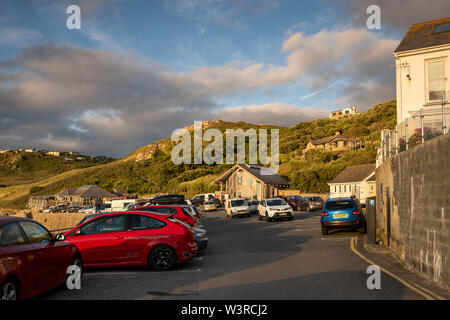 Tramonto sulla spiaggia parcheggio auto in Sennen Cove in Cornovaglia, England Regno Unito Foto Stock