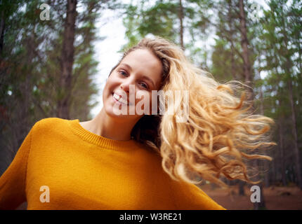 Ritratto di una giovane donna bionda con capelli di soffiatura Foto Stock