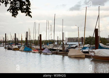 Barche a vela ormeggiate al molo del club di barche Blankeneser lungo il fiume Elba nel quartiere Blankenese di Amburgo, Germania, in una serata estiva. Foto Stock