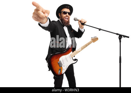 Uomo con una chitarra elettrica cantando su un microfono e puntamento isolati su sfondo bianco Foto Stock