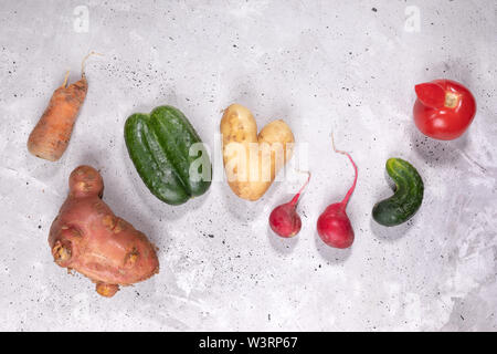 Piatto set di laici di freschi maturi brutto verdure sul cemento grigio Sfondo. Foto Stock