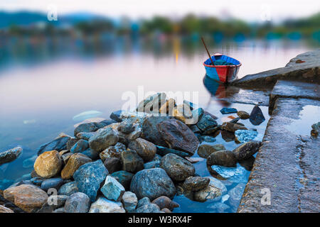 Singola in barca sul Lago Phewa e sfondo sfocato.Pokhara Nepal Foto Stock