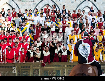 Una folla di fanatici dall'Owl contrada dei tifosi di fare il tifo per i loro team horse all annuale e storico evento del Palio di Siena, Italia Foto Stock