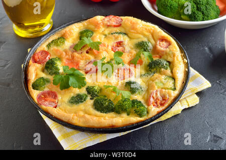 Frittata con broccoli e pomodori in padella Foto Stock