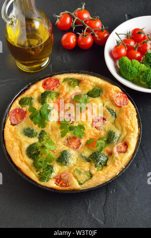 Frittata con broccoli e pomodori in padella Foto Stock