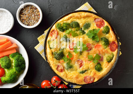 Frittata con broccoli e pomodori in padella, vista dall'alto Foto Stock