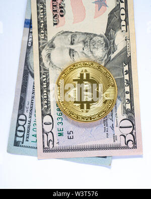 Un colore oro bitcoin su $50 e $100 US valuta le fatture isolato. Foto Stock