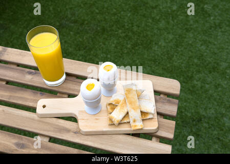 Uova fresche e toast a strisce con succo di arancia Foto Stock