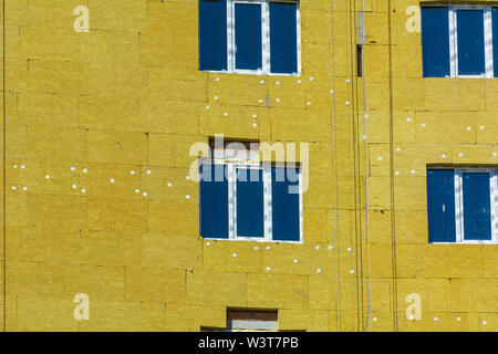 Ad alta altitudine lavorare sulle pareti esterne di isolante in lana di vetro e gesso Foto Stock