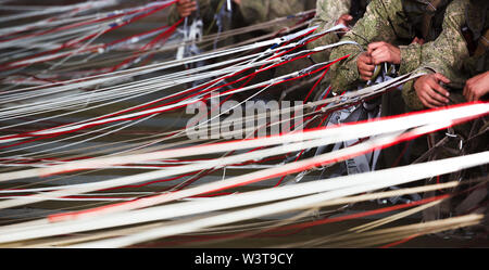 Le mani di soldati di raccogliere le linee con il paracadute. Preparazione al salto. Esercito Foto Stock