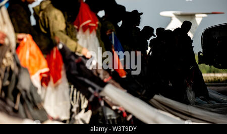 Le mani di soldati di raccogliere le linee con il paracadute. Preparazione al salto. Esercito Foto Stock