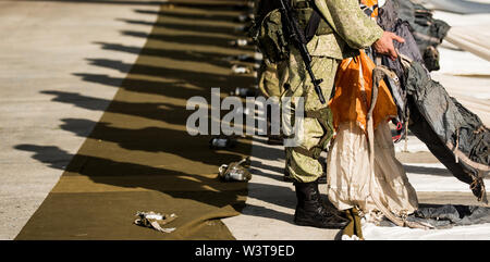 Le mani di soldati di raccogliere le linee con il paracadute. Preparazione al salto. Esercito Foto Stock